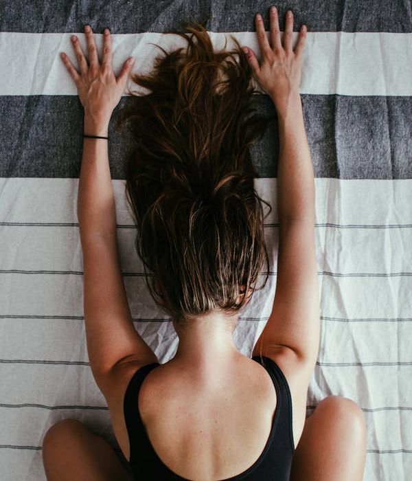 Woman performing a deep stretch, symbolizing flexibility and inner peace.